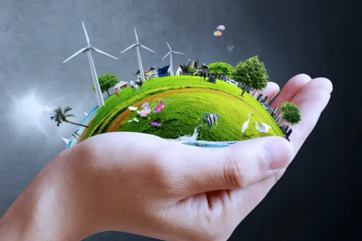 A hand holding an earth with wind turbines in the background.